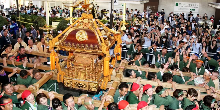 Fukuro Matsuri in Ikebukuro, Tokyo, with festival participants carrying an ornate golden mikoshi through a crowded street