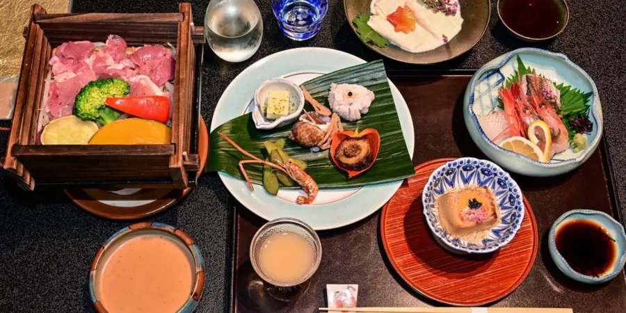 From top view, a shot of a kaiseki dinner including a variety of traditional Japanese dishes, from meat to salmon to vegetables