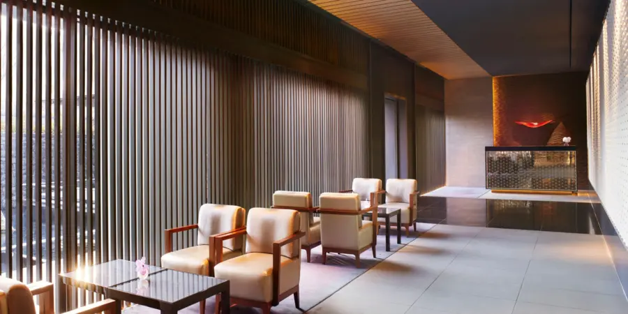 Lounge area of The Ritz Carlton Kyoto, with lounge chairs and ambient lighting.