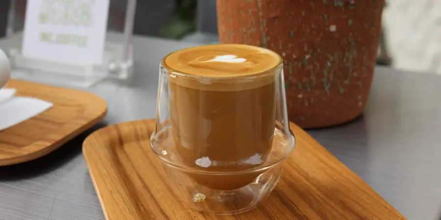 A latte in a clear glass from a cafe in Koenji