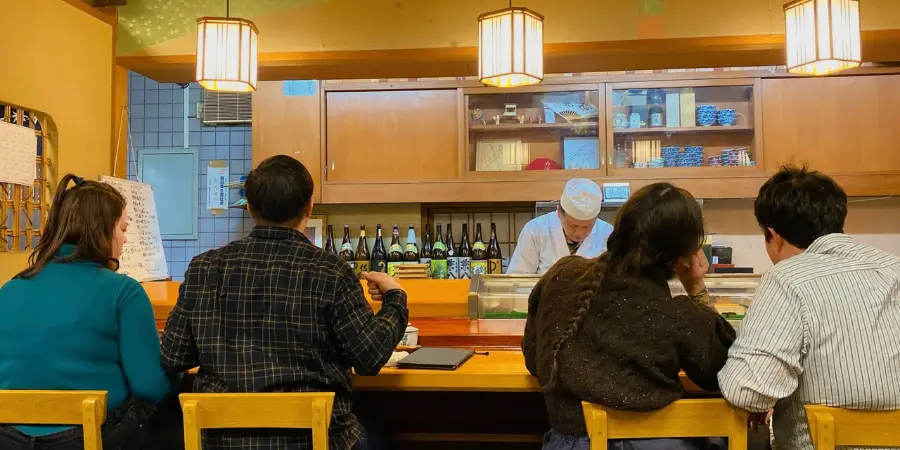 At the Kikyo Sushi restaurant - customers are seated by counters while watching the chef make their sushi dishes