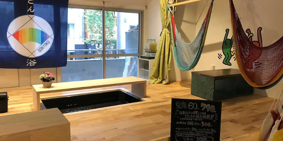 The interior of Donyoku, showcasing hammocks, footbaths, and low-rise dining tables