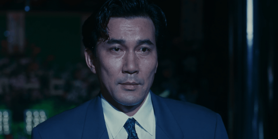 In the final ballroom scene, Mai Kishikawa (Tamiyo Kusakari) shines a dramatic spotlight onto a surprised Shohei Sugiyama (Kōji Yakusho), signaling him to be her final dance partner.