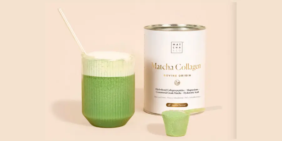 A tall glass of frothy, green Matcha Collagen drink next to the Matcha & Co. container and a scoop of the vanilla-flavored powder.HTML Caption