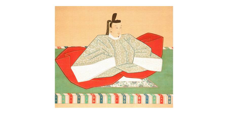 A traditional Japanese portrait painting of Emperor Go-Komatsu seated on a green tatami mat. He wears elaborate court robes featuring a light-colored, patterned outer garment over bright red under-robes, and a tall black eboshi hat. The background is a plain, neutral gold tone.