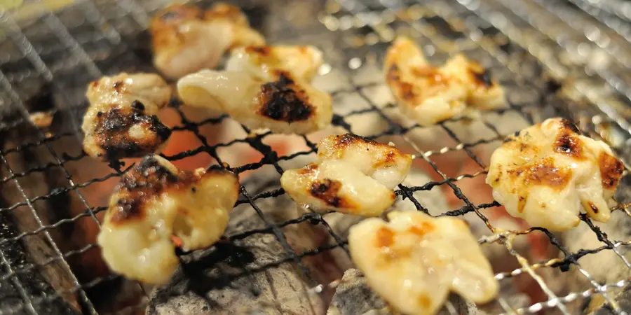 Offal meat being grilled over charcoal flame