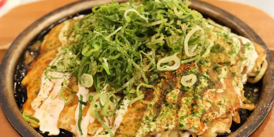 A plate of negiyaki, a savoury pancake with green onion toppings
