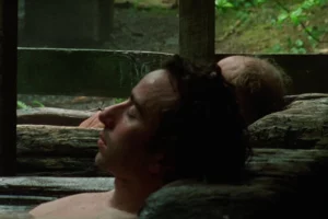man relaxing in outdoor onsen hot spring surrounded by nature in japan showcasing traditional bathing culture and peaceful relaxation experience.