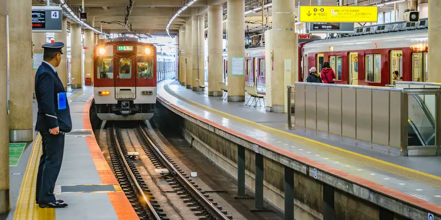 A train conductor awaits an upcoming subway train to approach the subway stop