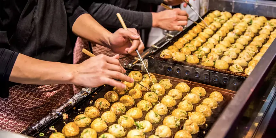 Takoyaki being cooked in a specialised takoyaki maker pan