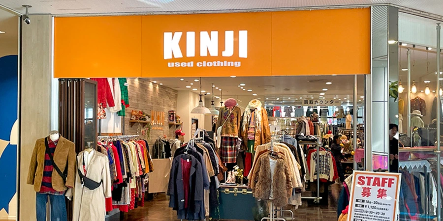 The front of Kinji store in Amemura, where various clothes for sale are displayed in racks.