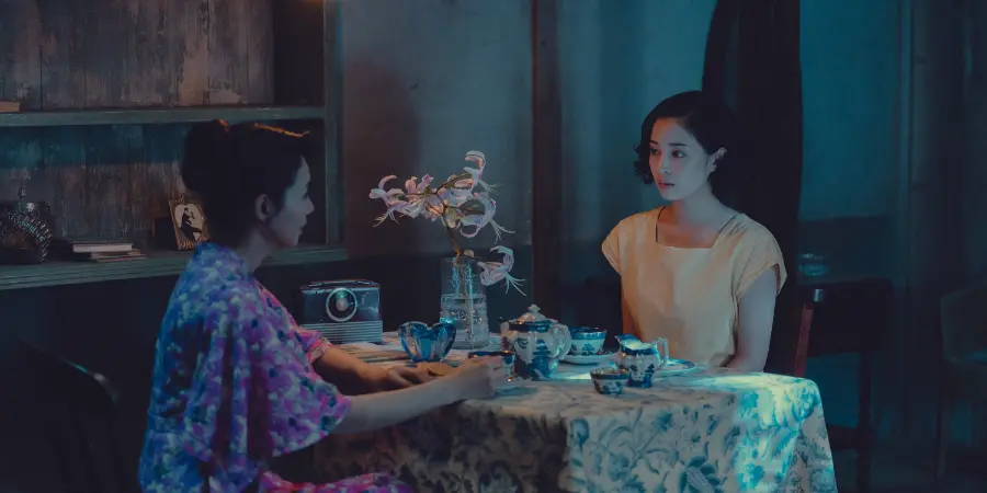 Etsuko and Sachiko sit across each other, with a tea set on the table between them