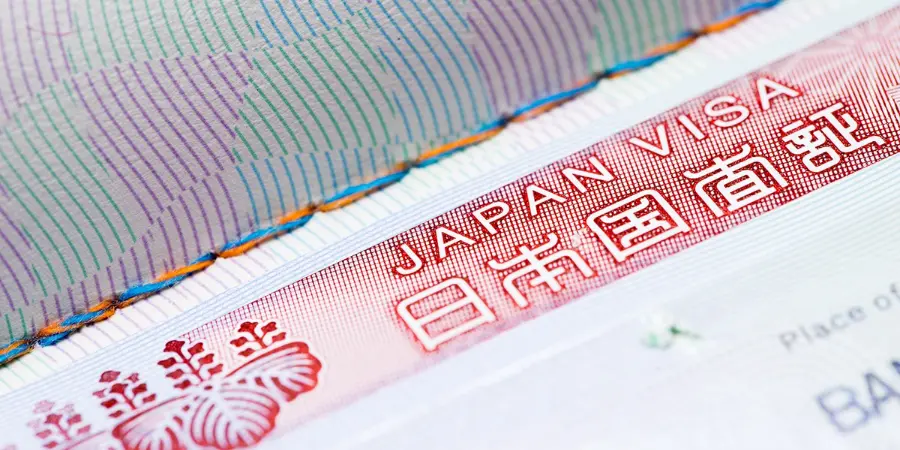 Close-up of a Japan visa sticker in a passport, showing “Japan Visa” text and Japanese characters with security patterns.