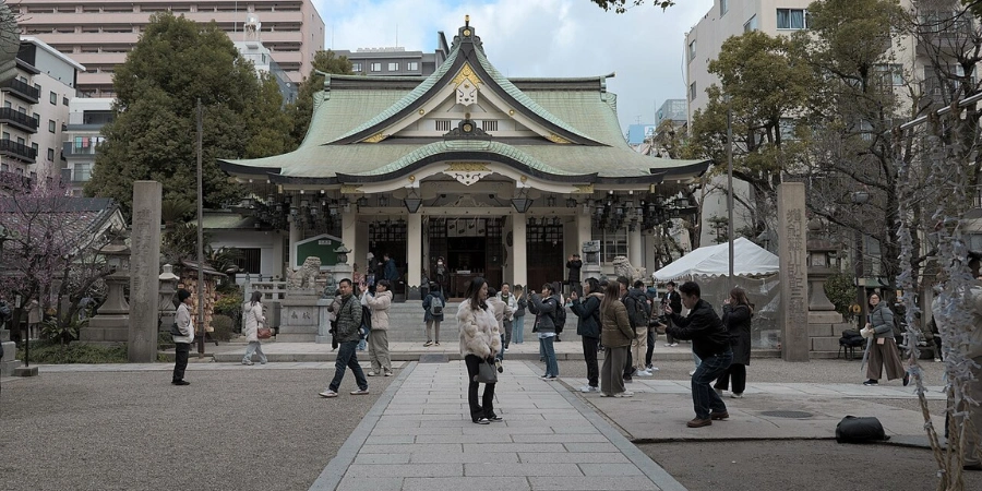 Diverse crowd of locals and tourists photographing the different areas of the shrine, capturing the shrine's vibrant atmosphere on a sunny day.