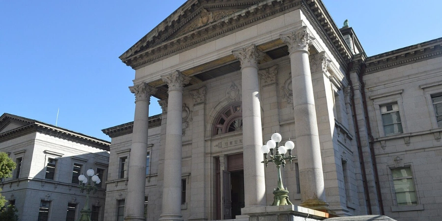 Ornate neo-baroque exterior of Osaka Prefectural Nakanoshima Library (1904), highlighting the copper-domed rooftop, symmetrical stone arches, grand columns, and intricate ironwork.