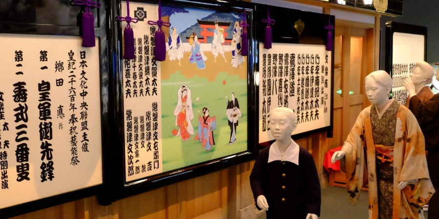 Kimono-clad mannequins portraying ancient Naniwa townspeople at Osaka Museum of History, displayed alongside historical scrolls and paintings that illustrate early Osaka's daily life and culture.