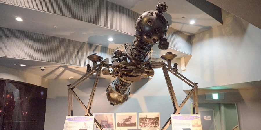 Historic Zeiss Planetary Model II projector, Japan's first planetarium machine from 1937, showcased in B1F Tsuice Square at Osaka Science Museum—gleaming brass gears, lenses, and celestial dials evoking vintage astronomy precision.