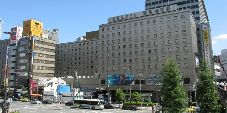Exterior view of New Hankyu Hotel towering above Osaka Station, offering convenient accommodations with direct station access and cityscape backdrop.