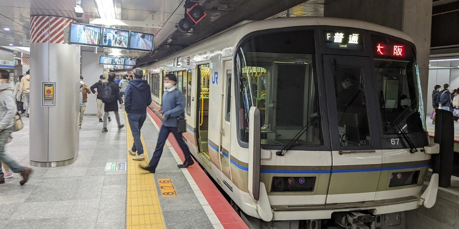 Modern Osaka Higashi Line train at Umekita area platform, highlighting sleek design and station infrastructure amid Umeda skyscrapers.