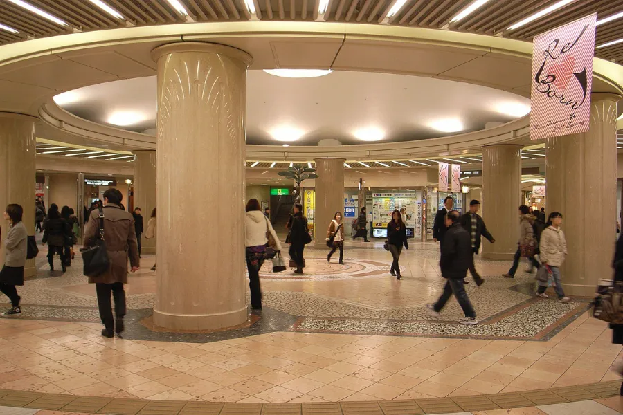 Interior view of Diamor Osaka's central shopping arcade in Umeda, captured on March 10, 2011, featuring elegant storefronts, marble flooring, and bright skylights evoking an Italian townscape.