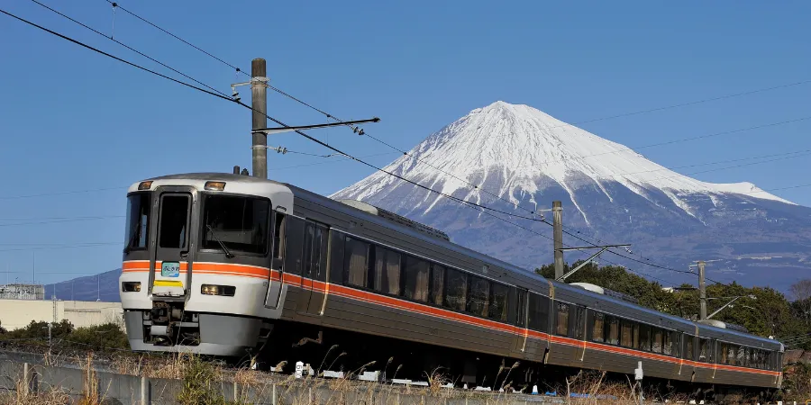 Fujikawa train passing beneath Mount Fuji in Shizuoka Prefecture, Japan