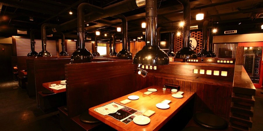 Interior of Rikimaru Shinsaibashi yakiniku restaurant in Osaka with private grill booths and Japanese barbecue seating