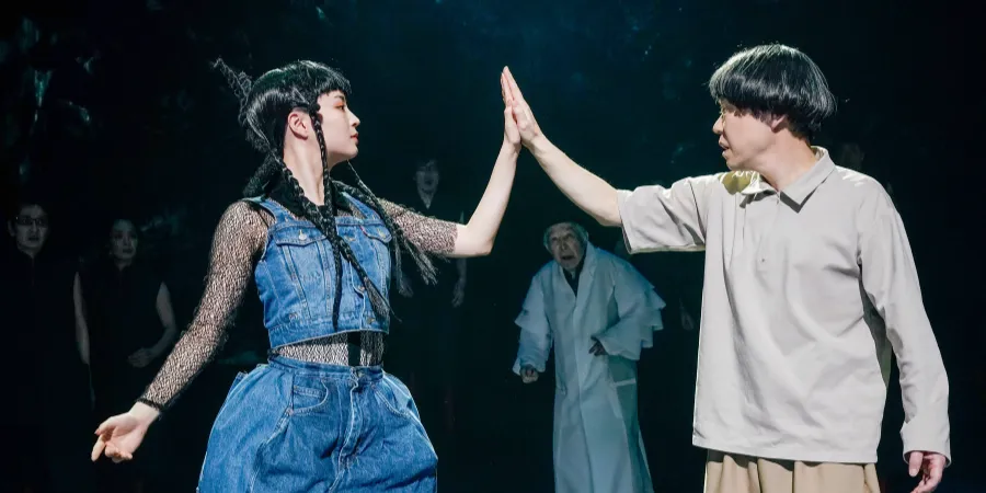 Theatre performers sharing a high five during the 320°F Play stage performance, featuring contemporary drama, expressive acting, and live theatrical movement under stage lighting