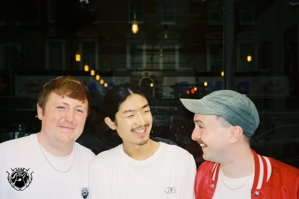 AZAZ Collective founders Kazuki, Joe and John smiling together, reflecting the London-based music, fashion and community collective they founded in 2025.
