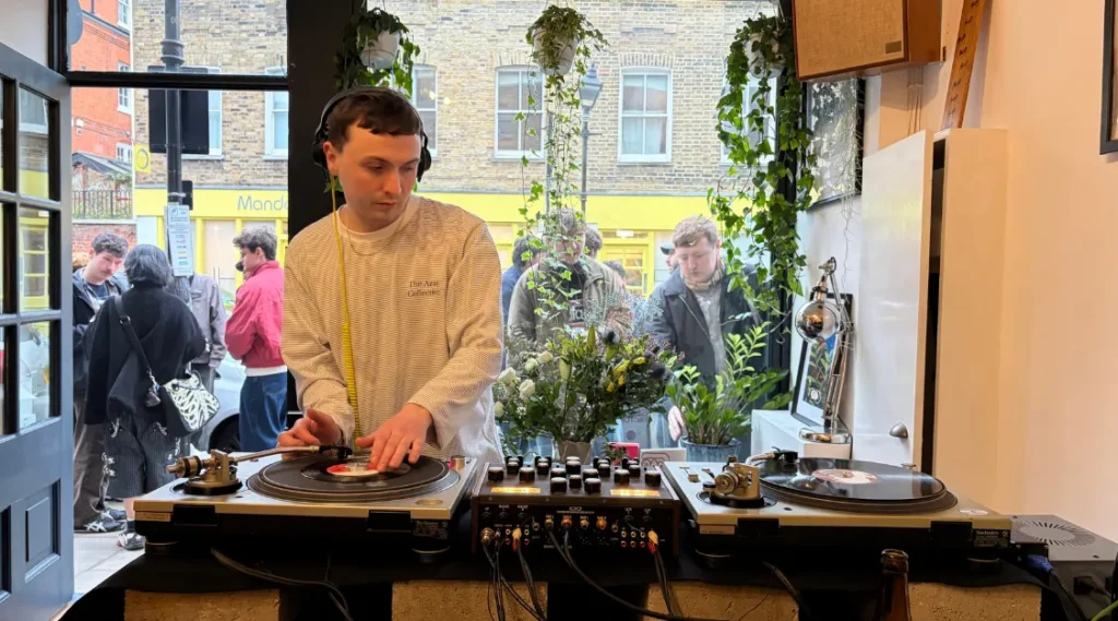 AZAZ Collective DJ Joe playing vinyl at Katsute100, with turntables set up beside the Broadway Market entrance.