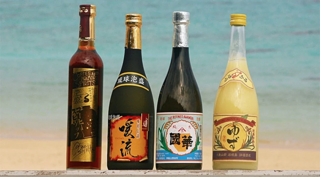 Four bottles of Okinawan awamori spirits displayed together, showcasing different labels and styles of the traditional Japanese distilled drink.
