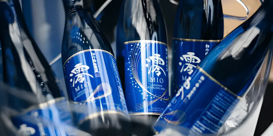 Blue MIO sparkling sake bottles arranged together in a chilled display