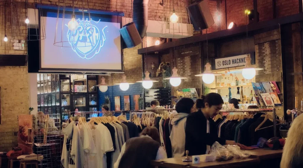 AZAZ Collective pop-up at Oslo Hackney, with clothing rails, guests and the collective’s logo projected above the venue.