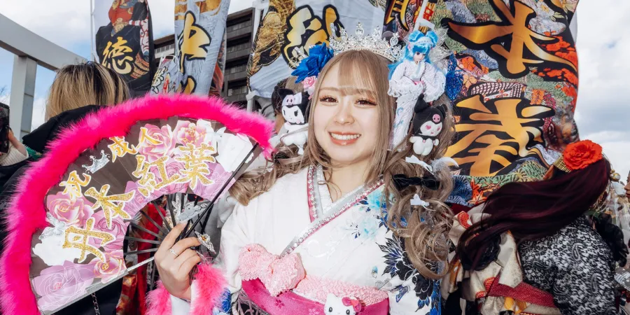 Young woman in an elaborate furisode kimono holding a decorated fan during a Coming-of-Age Day celebration in Kitakyushu, Japan
