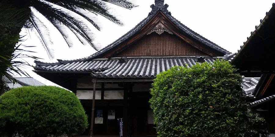 Traditional Japanese temple building with tiled roof and manicured trees at Hotokuji Temple