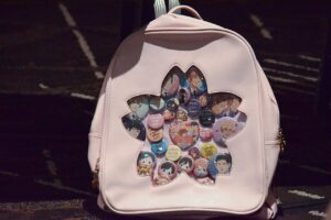 Pale pink ita-bag backpack with a flower-shaped clear window filled with badges of Ouran High School Host Club characters