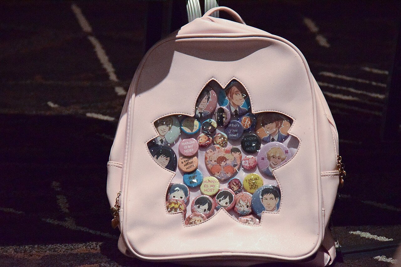 Pale pink ita-bag backpack with a flower-shaped clear window filled with badges of Ouran High School Host Club characters