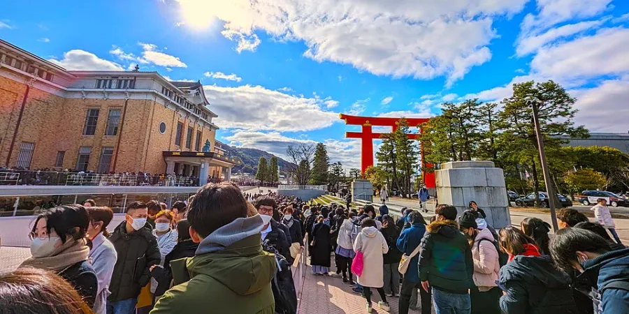 Visitors walking past the Kyocera Museum of Art toward the large torii gate of Heian Shrine in Kyoto