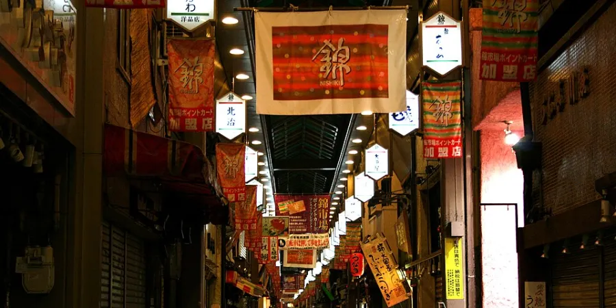 Nishiki Market covered shopping arcade in central Kyoto filled with traditional shops, signs and lanterns