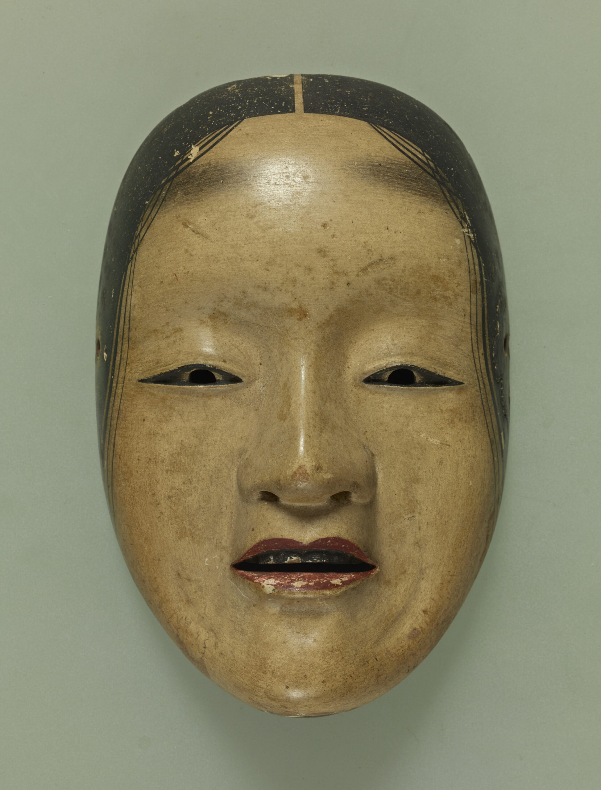 A Shakumi Noh mask, the face of a woman past her youth on the edge of madness, held by the Tokyo National Museum.