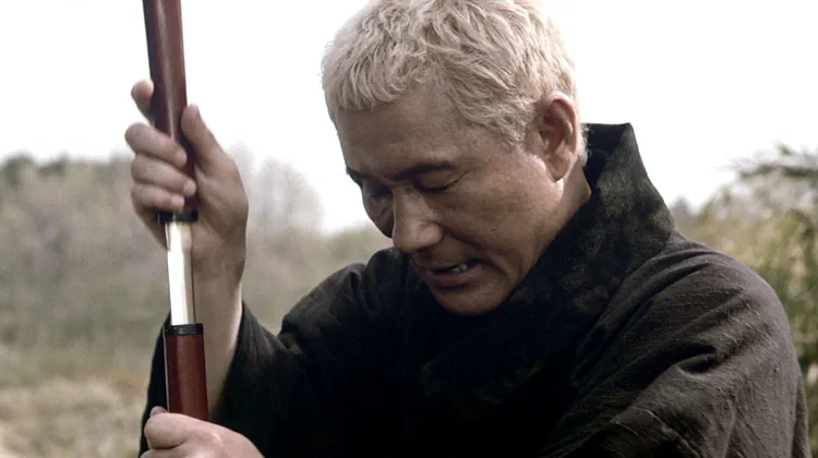 Takeshi Kitano as Zatoichi drawing the hidden blade from his cane sword in his 2003 film.