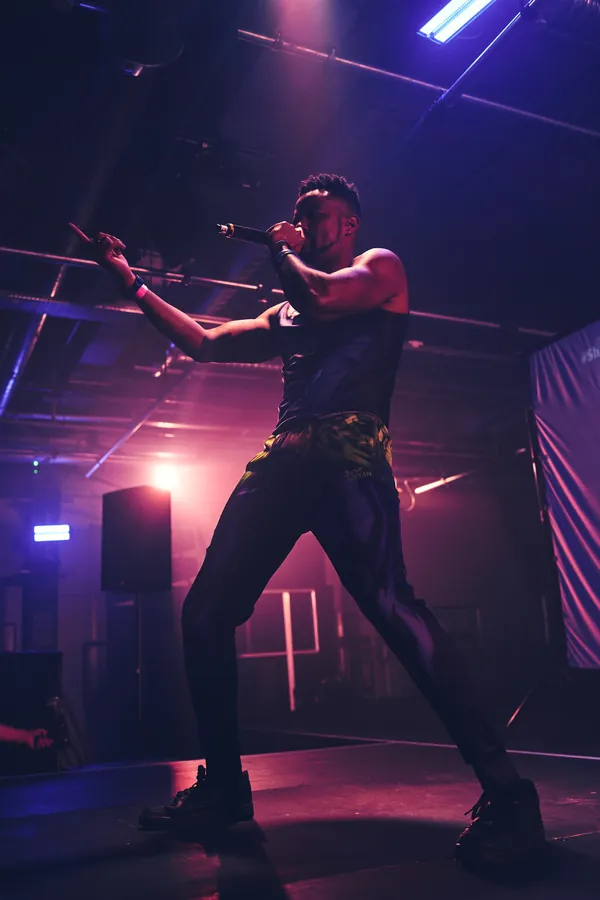 A performer on stage in front of a crowd at the AnimeCon London 2024 after party