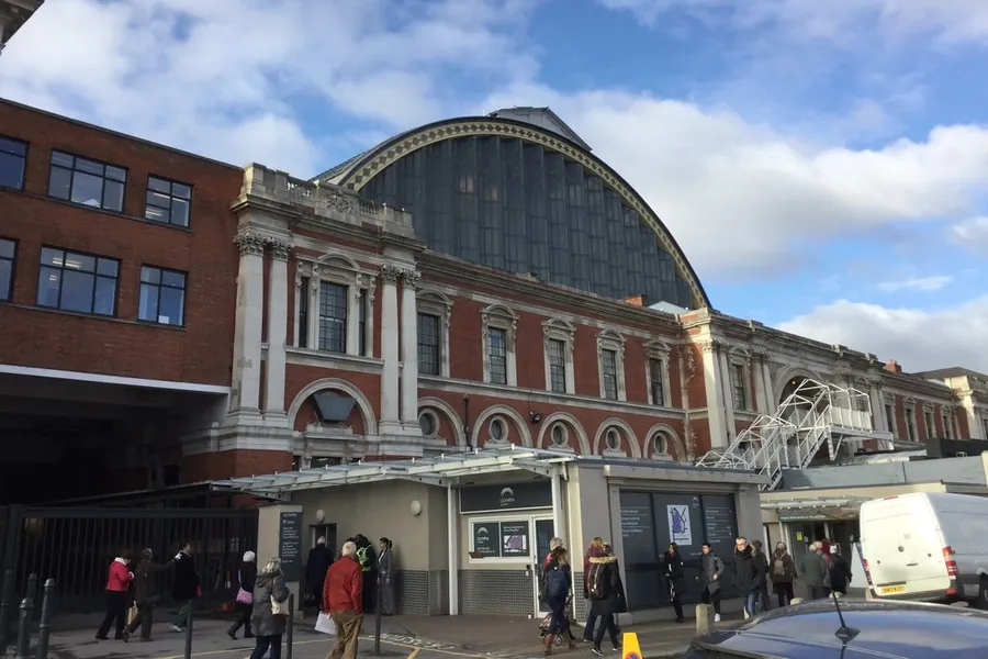 The arched glass roof and red brick frontage of Olympia London on Hammersmith Road