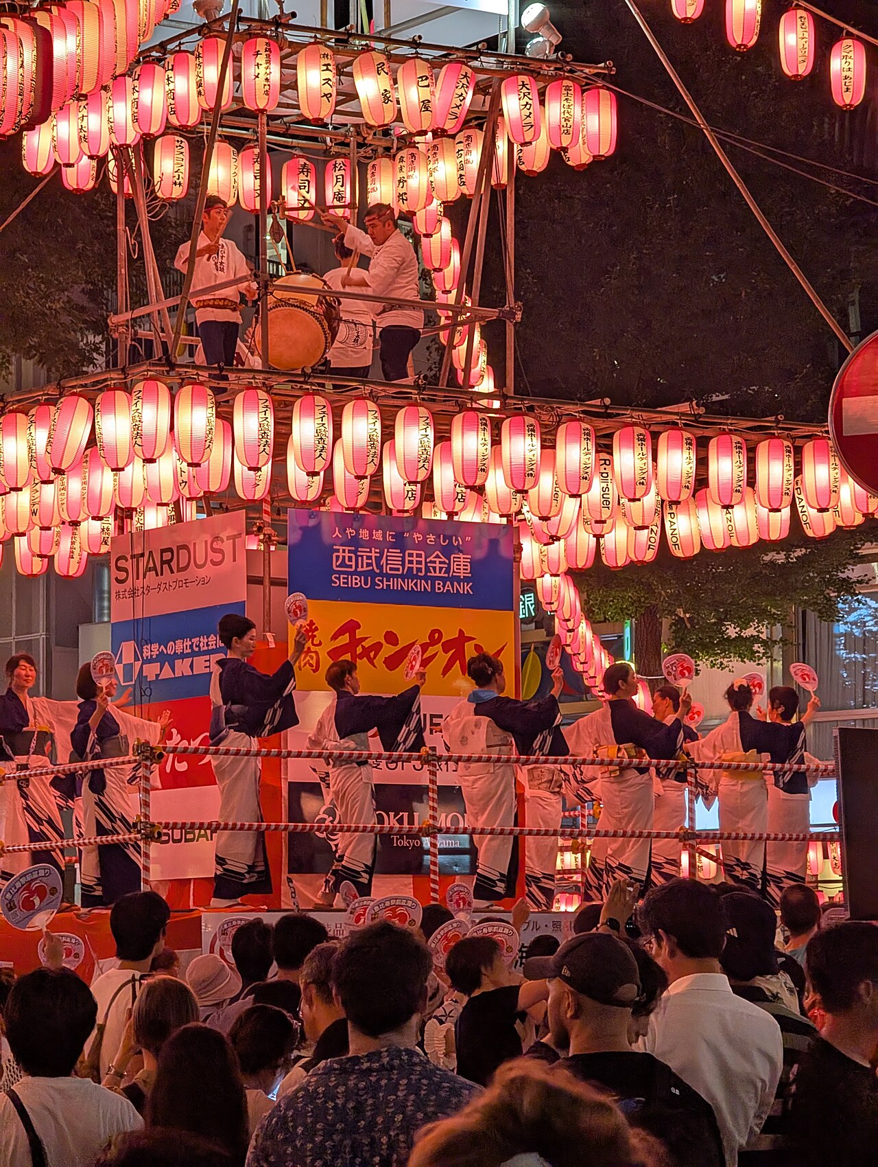 Drummers on a lantern-hung yagura tower with dancers circling below at the Ebisu Bon Odori in July 2025
