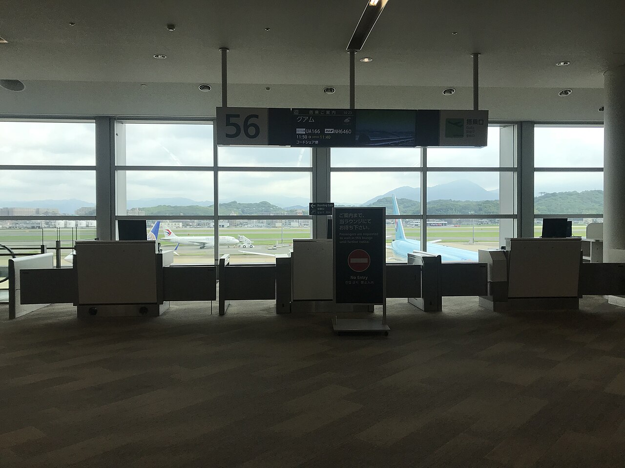 Boarding Gate 56 at Fukuoka Airport International Terminal, with the gate desk in front of windows looking out over the apron