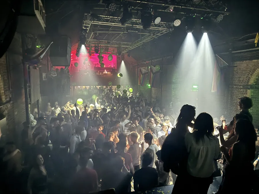 A packed crowd in the main room of Heaven nightclub in London, seen from the stage under coloured lights