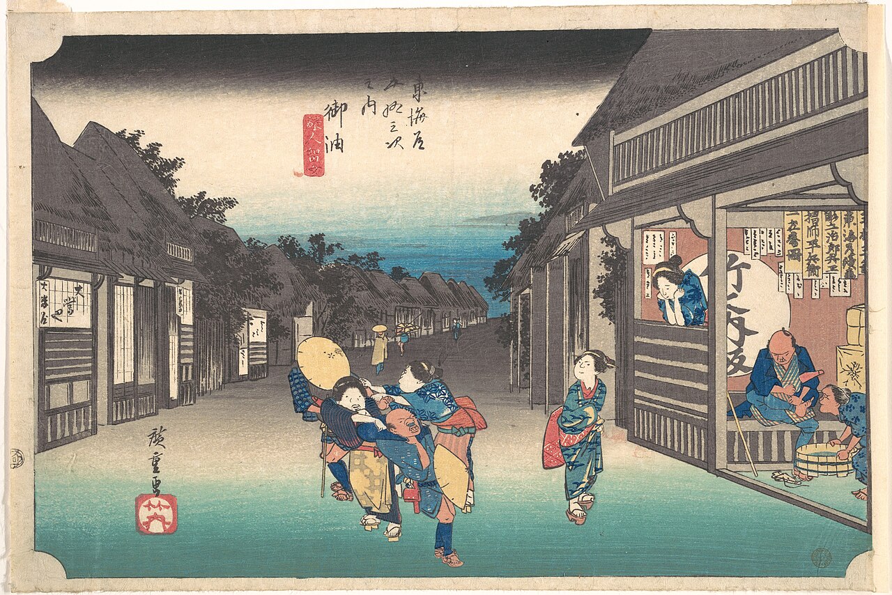 Hiroshige woodblock print of inn maids pulling travellers into their inns along the Tokaido at Goyu
