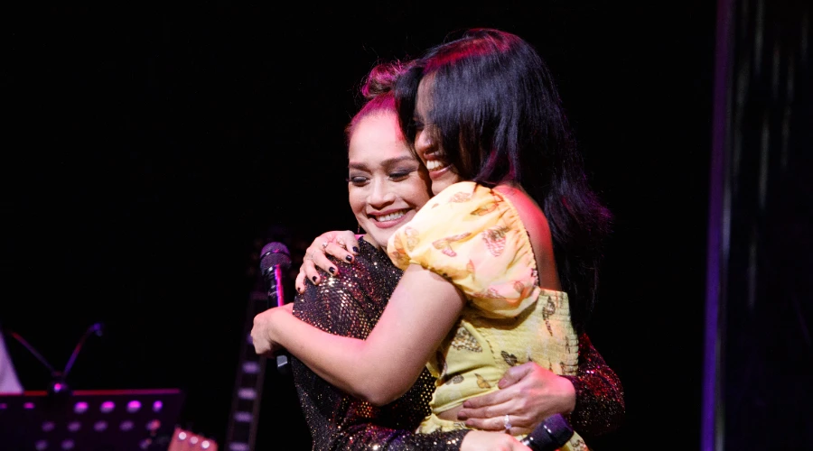 Joanna Ampil and Desmonda Cathabel embracing on stage at RepresentAsian 2025