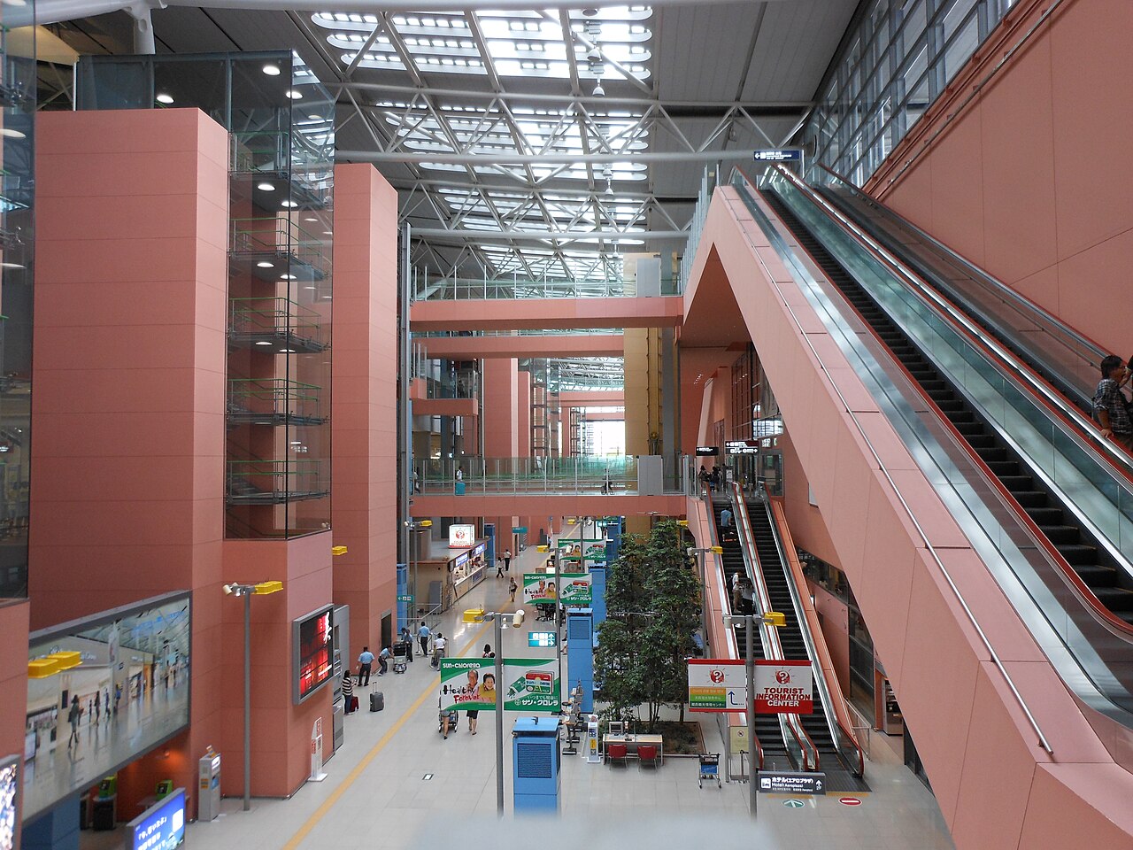 The multi-level interior of Kansai International Airport Terminal 1, with escalators, glass lifts and a glazed roof