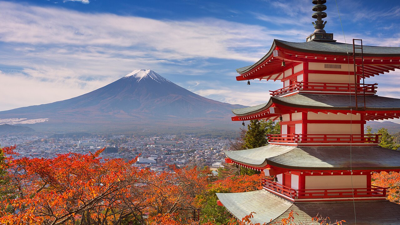 Snow-capped Mount Fuji behind the red five-storey Chureito Pagoda, framed by autumn maple leaves