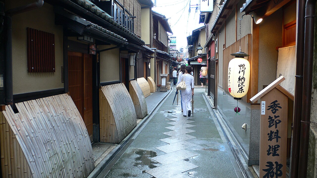 The narrow stone-paved Pontocho alley in Kyoto lined with wooden restaurant fronts and paper lanterns